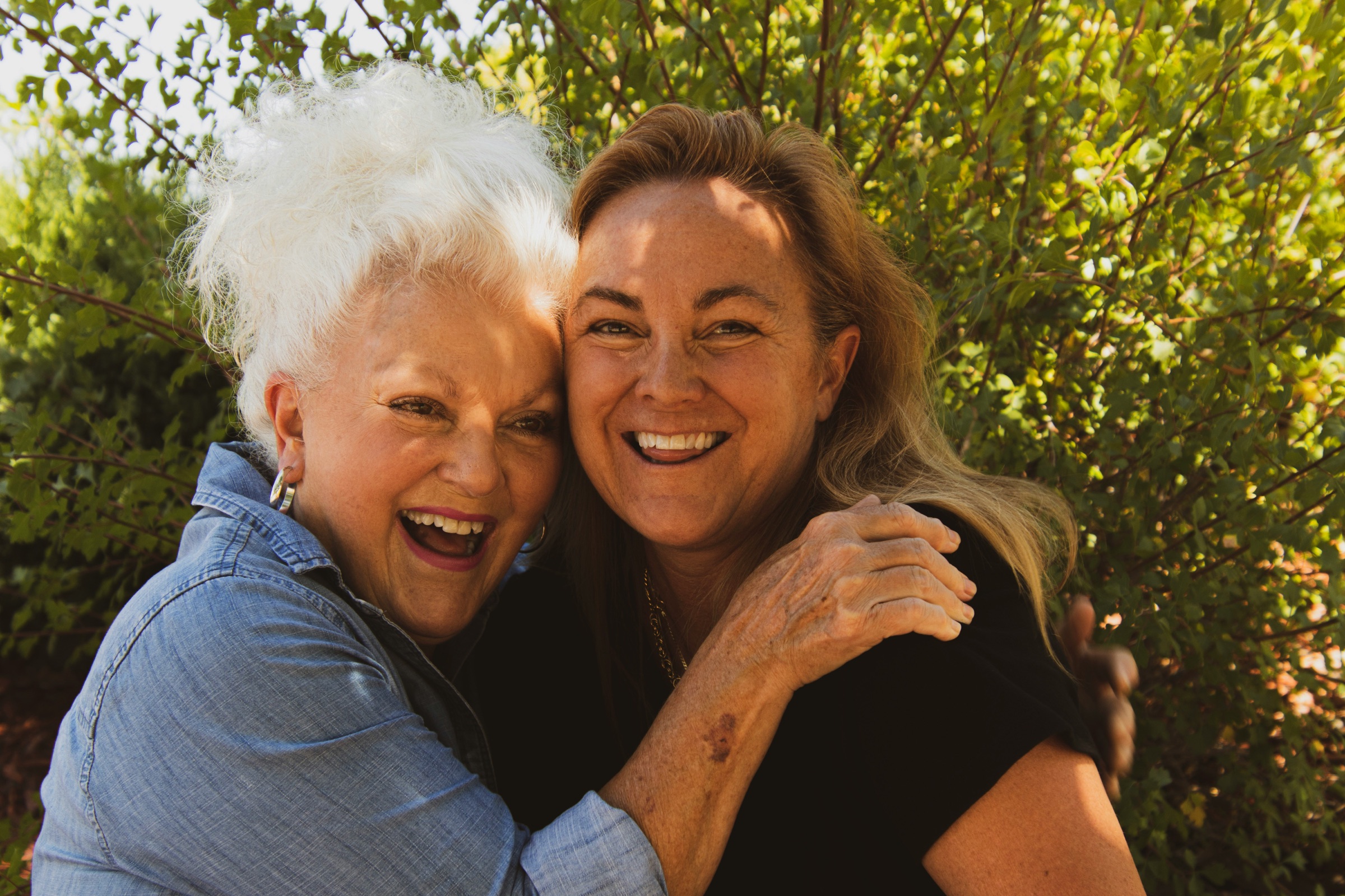 A mother and daughter laughing together outdoors